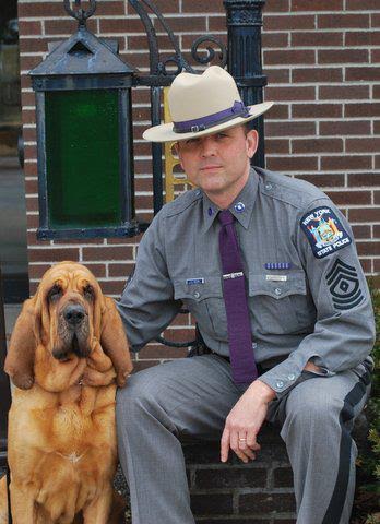Darby the bloodhound, poses with her old friend, now Hudson Police Chief L. Edward Moore on his last day as a State Police sergeant in 2013. Photo contributed 